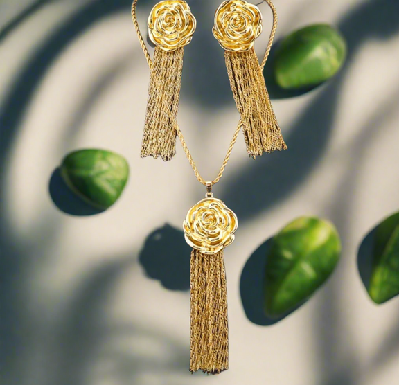 Gold rose-shaped earrings & necklace with cascading chain tassels, displayed on a white background with black text