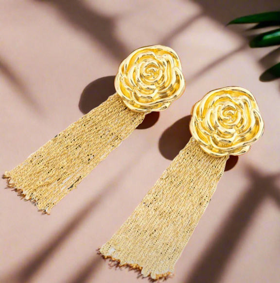 Gold rose-shaped earrings with cascading chain tassels, displayed on a white background with black text