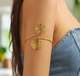 Gold-tone double spiral arm cuff, adjustable upper arm bracelet with twin swirl design, bold minimalist boho chic jewelry.
