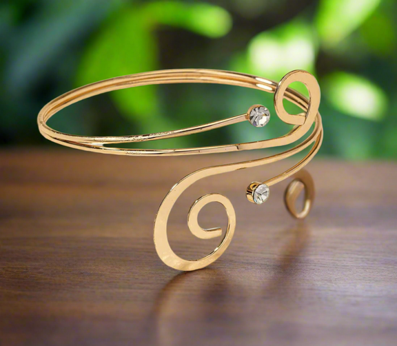 Minimalist gold-tone spiral arm cuff bracelet with crystal accents, elegant open bangle for women, adjustable and lightweight.