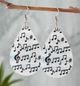 Teardrop-shaped earrings with black musical notes printed on a white background, featuring silver hooks, perfect for music lovers and musicians.