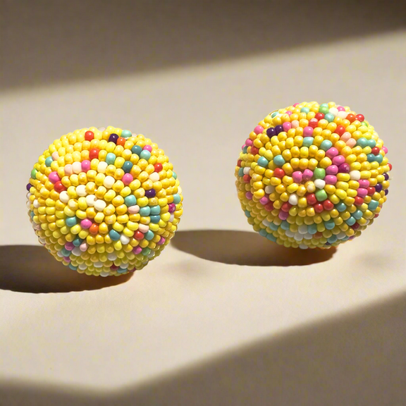 Round beaded stud earrings with vibrant yellow, pink, blue, and white seed beads, displayed on a white background with gold polka dots.