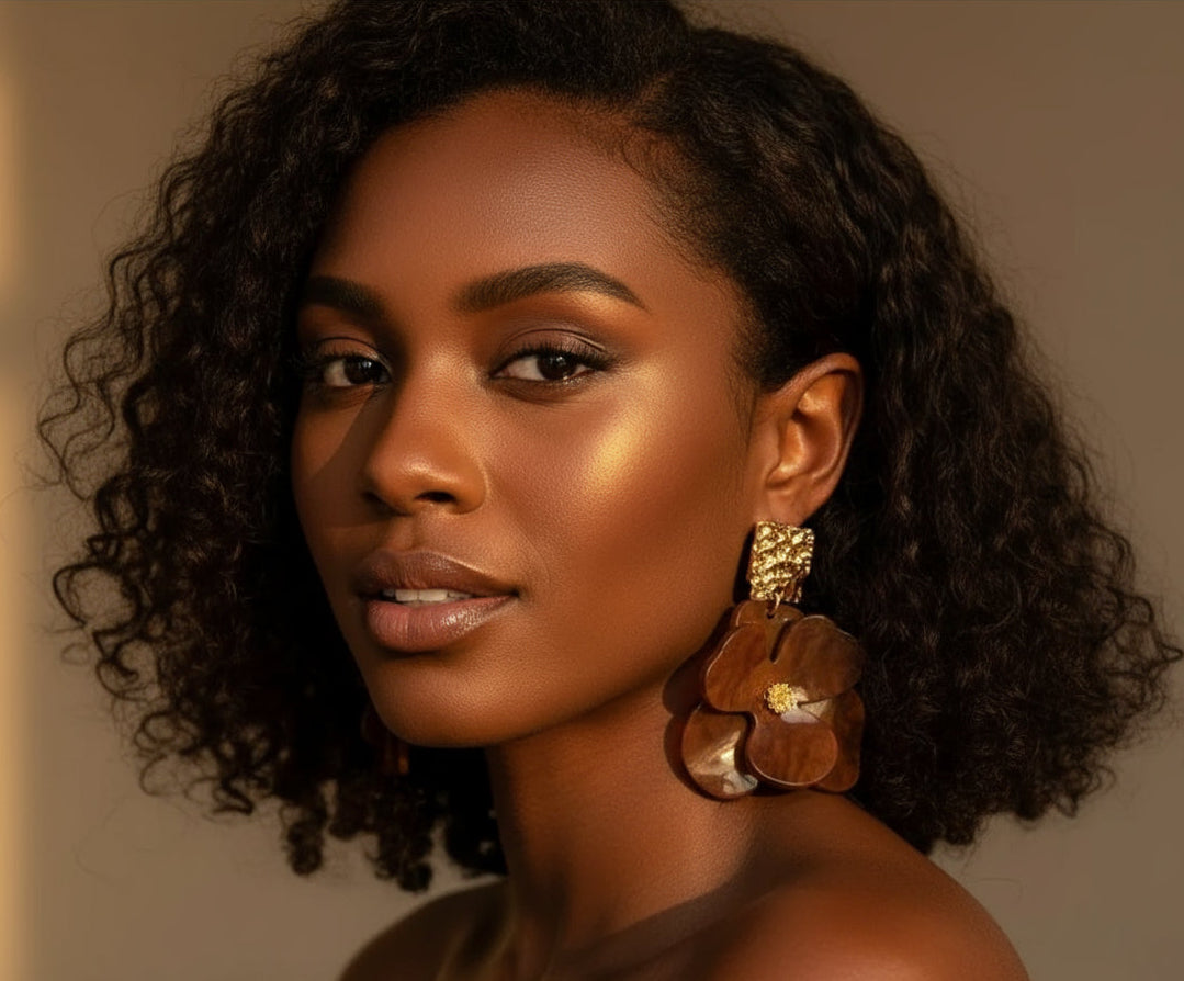 Ayira Amber Petal Earrings — elegant brown floral statement earrings with layered resin petals and textured gold stud tops, reflecting warm golden light for a regal, sophisticated look.