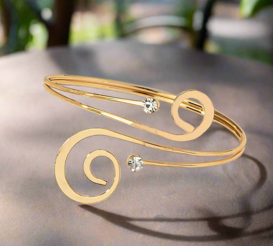 Minimalist gold-tone spiral arm cuff bracelet with crystal accents, elegant open bangle for women, adjustable and lightweight.