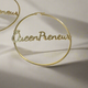 A pair of large, elegant gold hoop earrings featuring the word “QueenPreneur” in a bold cursive script, with a delicate crown accent over the “Q.” The earrings have a secure latch-back closure and a stylish, empowering design perfect for entrepreneurs and boss queens.