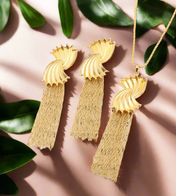 Gold sculpted swirl tassel necklace with a long chain and elegant fringe detail, displayed on a white background with text