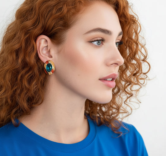 Close-up of a woman wearing a colorful earring with a blue background