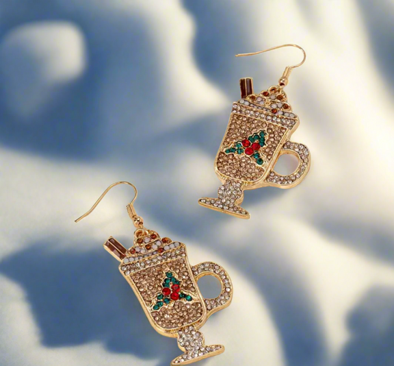 Holiday Cocoa Sparkle Earrings shaped like festive hot chocolate mugs with whipped cream, cinnamon sticks, and colorful crystal accents in gold, red, and green.