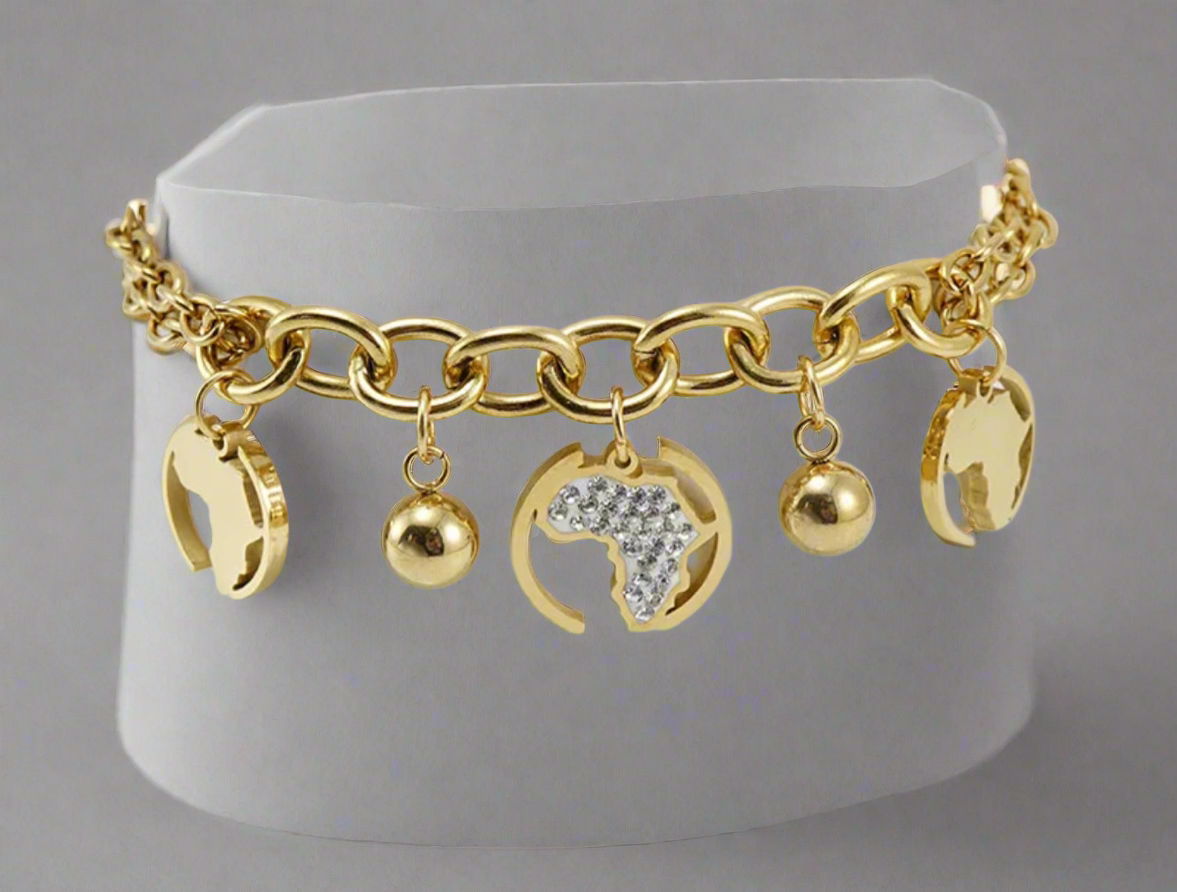 “Gold Africa charm bracelet with double link chain, gold map cutouts, rhinestone accents, and polished gold spheres, displayed on a white background.”
