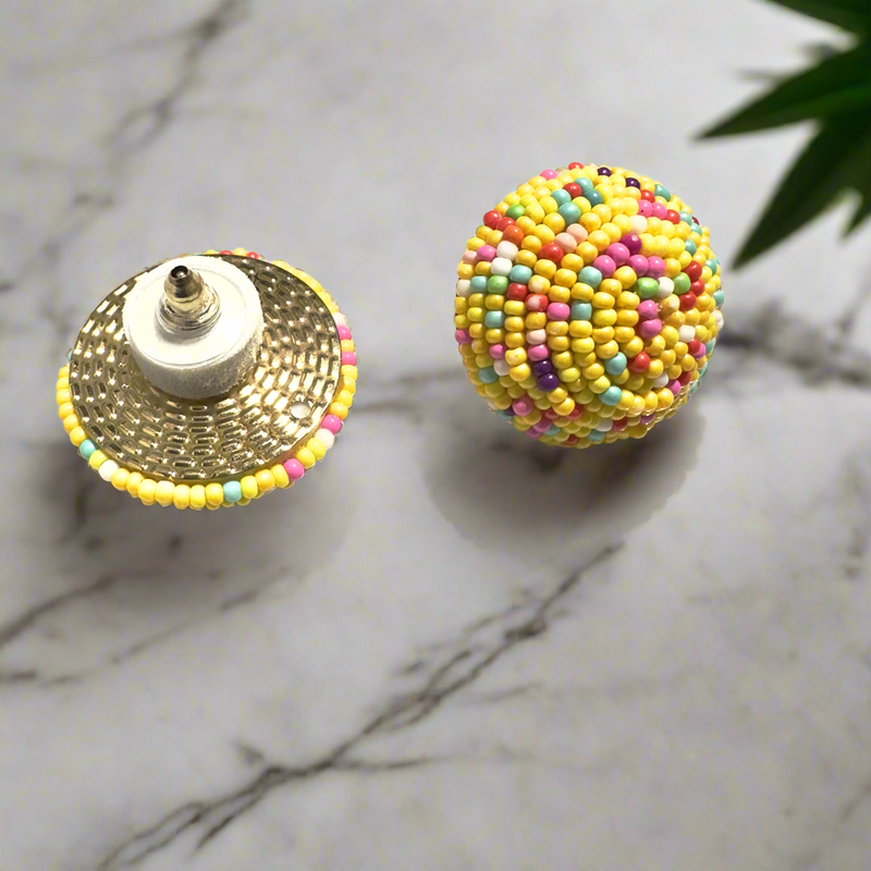 Round beaded stud earrings with vibrant yellow, pink, blue, and white seed beads, displayed on a white background with gold polka dots.