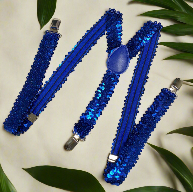 Blue sequin suspenders with Y-back design and silver clips displayed on a light wooden surface.