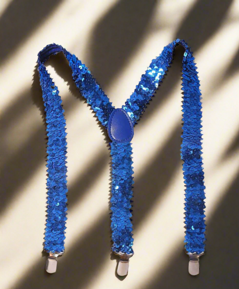 Blue sequin suspenders with Y-back design and silver clips displayed on a light wooden surface.