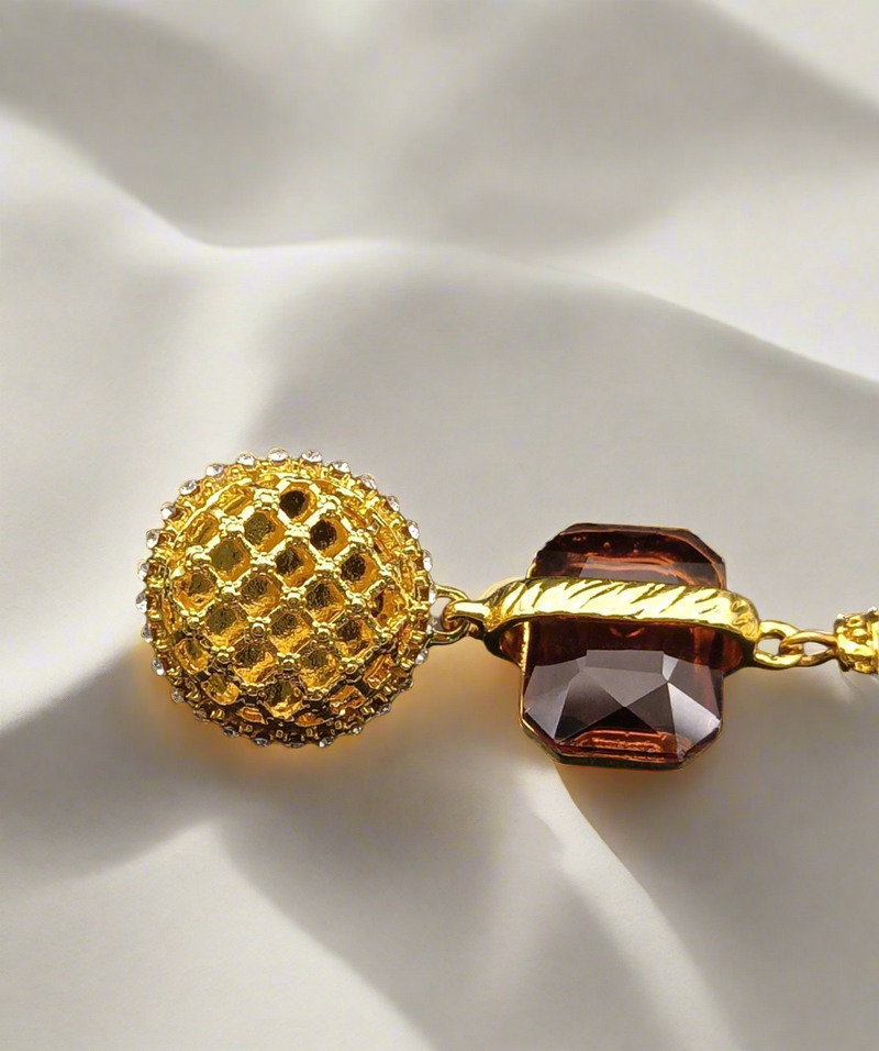 Adira Royal Tassel Earrings featuring a textured gold stud, brown gemstone, and elegant cascading gold and silver tassels – a bold and luxurious statement piece.