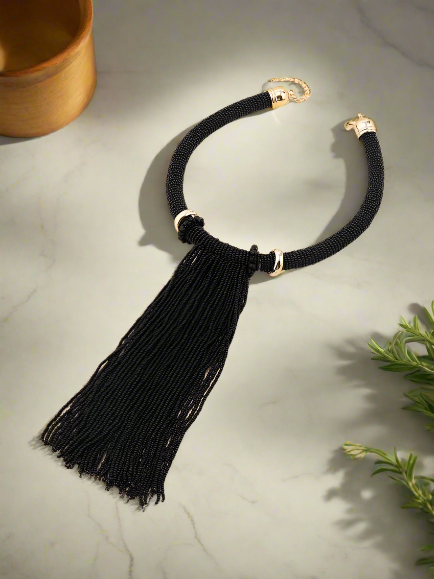 Elegant handmade black beaded tassel necklace with gold-tone accents, featuring a bold statement design perfect for evening wear and special occasions.