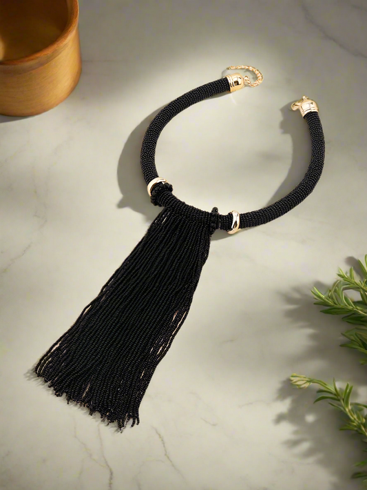 Elegant handmade black beaded tassel necklace with gold-tone accents, featuring a bold statement design perfect for evening wear and special occasions.