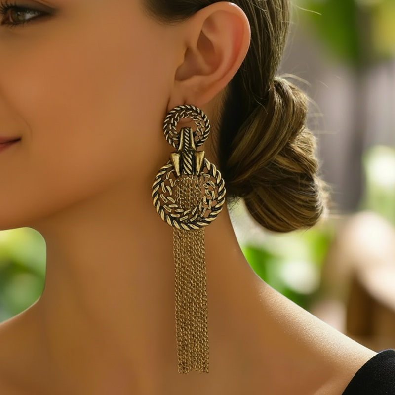 Close-up of a person wearing a gold earring with tassels.