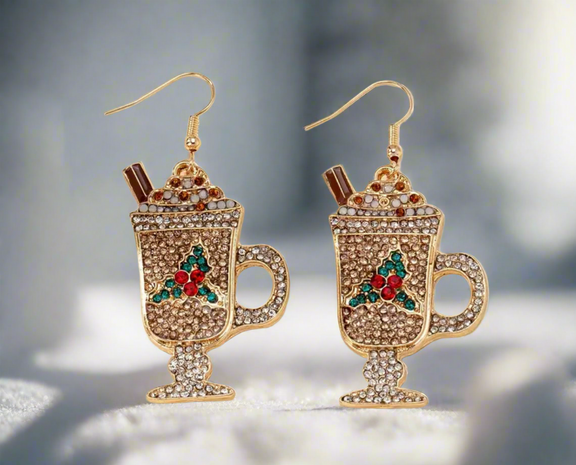 Holiday Cocoa Sparkle Earrings shaped like festive hot chocolate mugs with whipped cream, cinnamon sticks, and colorful crystal accents in gold, red, and green.