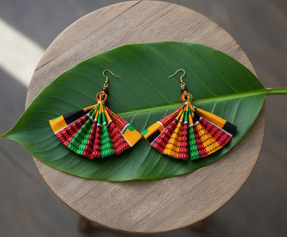 Colorful earrings on a green leaf with a wooden background
