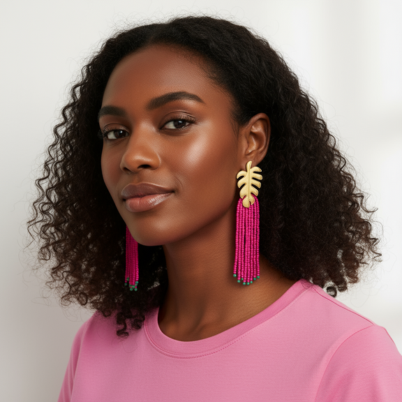 Woman wearing pink tassel earrings with a neutral background