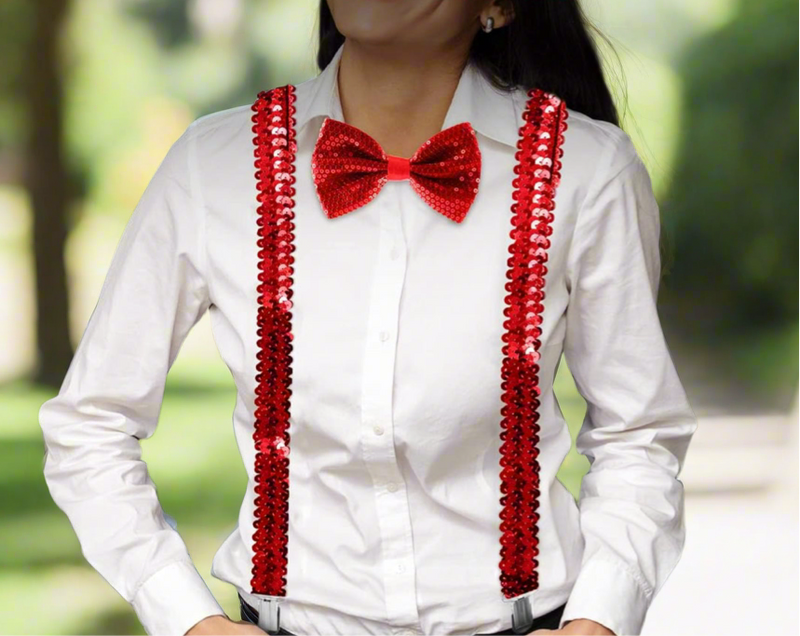 Red sequin suspenders with Y-back design and silver clips displayed on a light wooden surface.