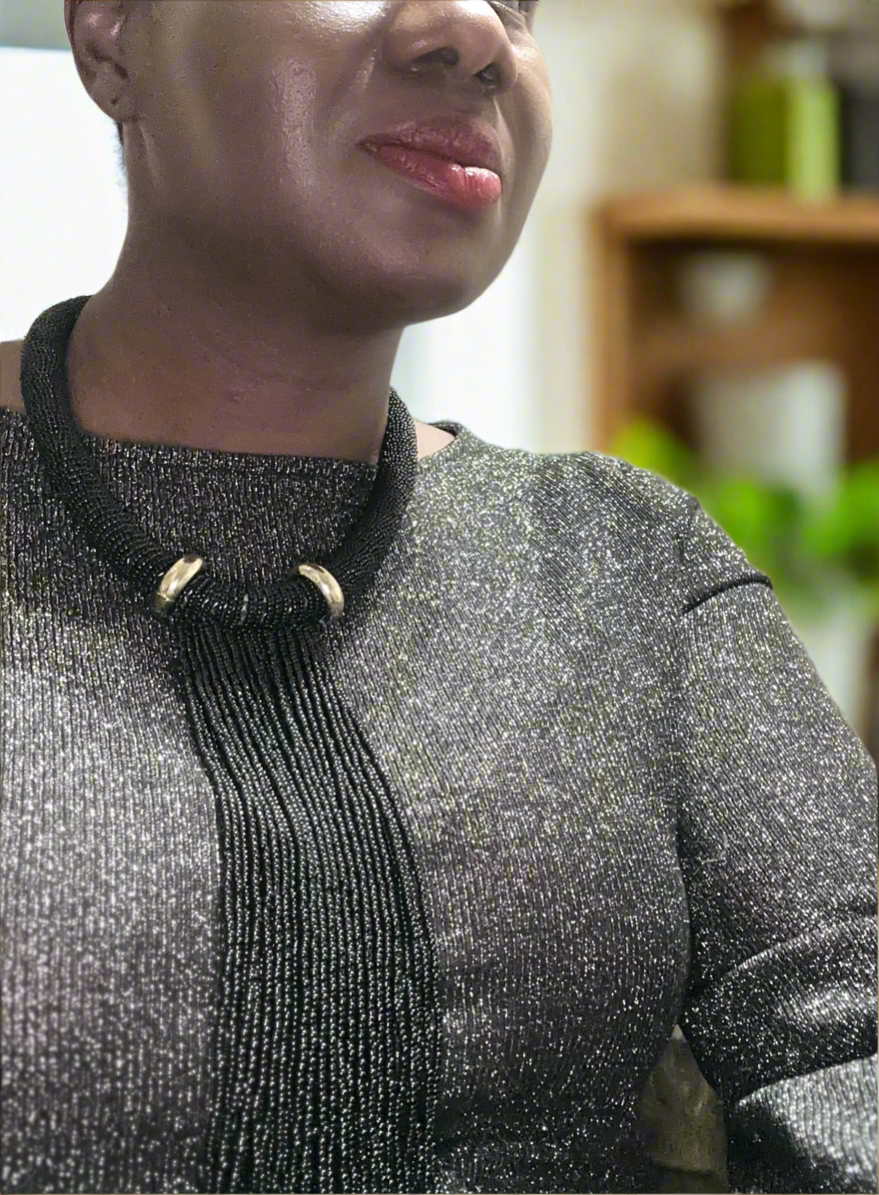 Elegant handmade black beaded tassel necklace with gold-tone accents, featuring a bold statement design perfect for evening wear and special occasions.