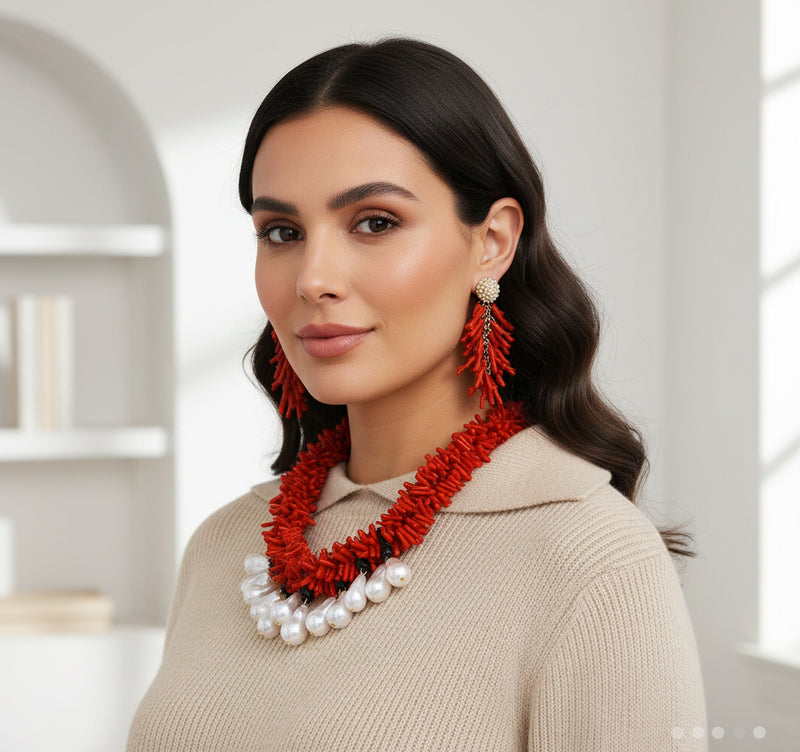 Woman wearing a red necklace and earrings indoors