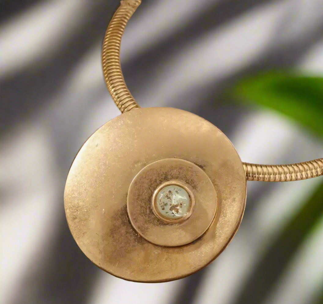 Gold statement necklace with large 2.5-inch disc pendant and 14-inch collar chain with extender on satin background