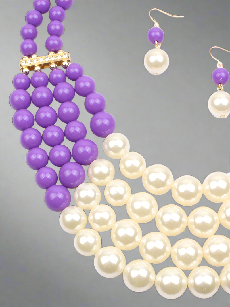 A luxurious layered necklace featuring rich purple beads and classic white pearls, paired with matching drop earrings. A statement jewelry set fit for a queen, perfect for elegant occasions and everyday glam.