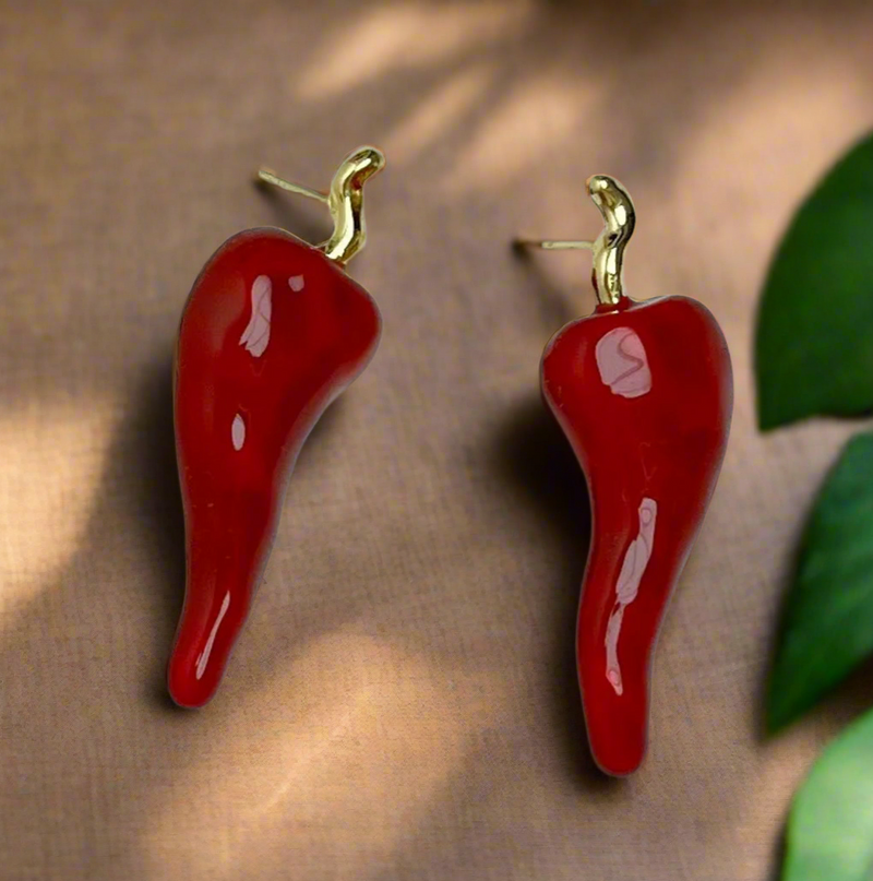 Glossy red chili pepper-shaped stud earrings with gold-tone stems on a white background.
