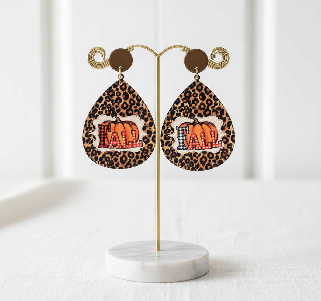 Shop the Liona Autumn Roar Earrings — bold leopard print teardrops with a pumpkin “FALL” design. Lightweight statement earrings that radiate autumn confidence. 