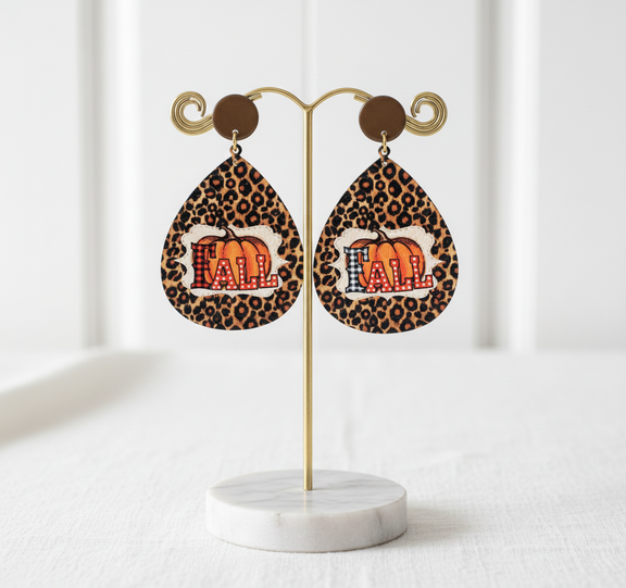 Shop the Liona Autumn Roar Earrings — bold leopard print teardrops with a pumpkin “FALL” design. Lightweight statement earrings that radiate autumn confidence. 