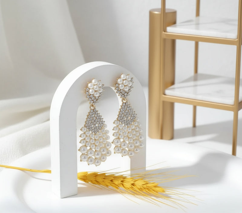 Modestine Cascade Earrings — elegant gold statement earrings featuring cascading pearls and sparkling crystals, perfect for weddings and special occasions.