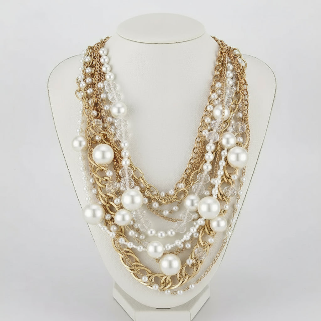 Multistrand pearl and chain necklace on a black mannequin with matching earrings.