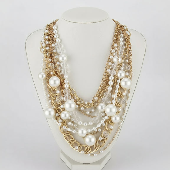 Multistrand pearl and chain necklace on a black mannequin with matching earrings.