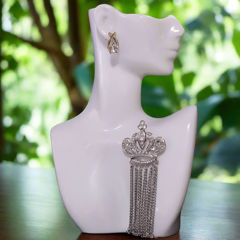 Command the spotlight with this regal crown brooch, embellished with dazzling rhinestones and cascading chain tassels. Its elegant silver-tone metal finish adds a touch of sophistication to any outfit, while the graceful fringe brings movement and flair. 