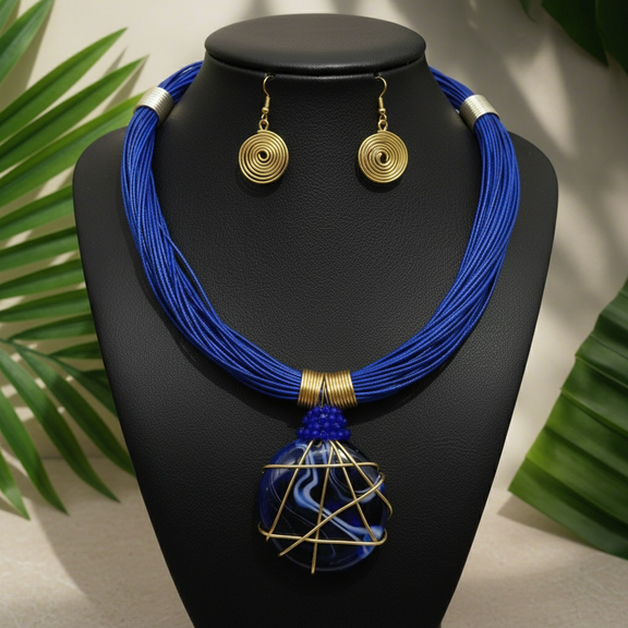 Bold African-inspired amber resin necklace wrapped in gold wire, featuring brown layered cords and matching gold coil earrings, handcrafted jewelry for women.