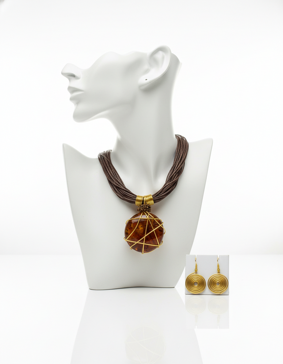 Bold African-inspired amber resin necklace wrapped in gold wire, featuring brown layered cords and matching gold coil earrings, handcrafted jewelry for women.