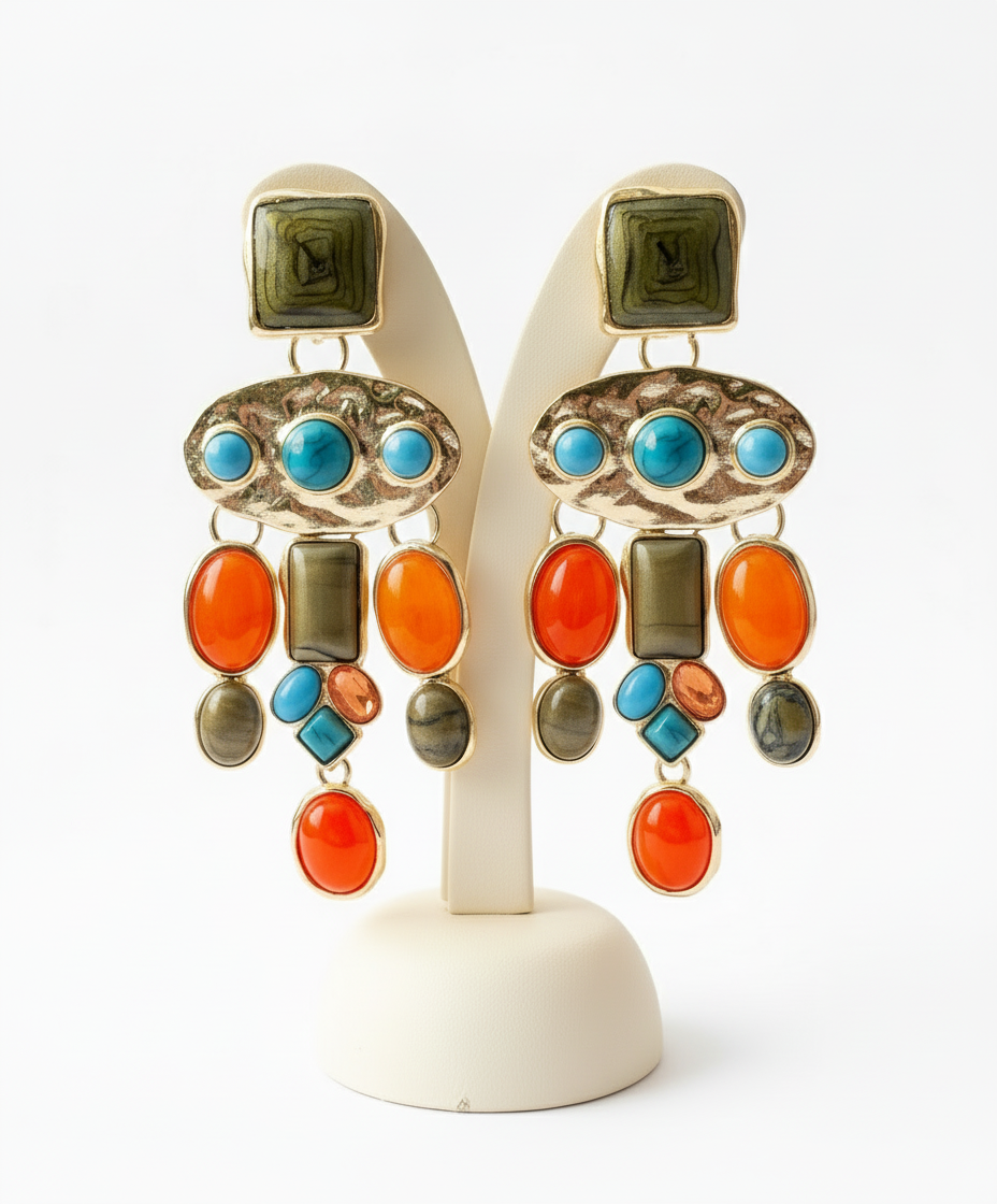Colorful earrings with turquoise, orange, and green stones on a white stand.