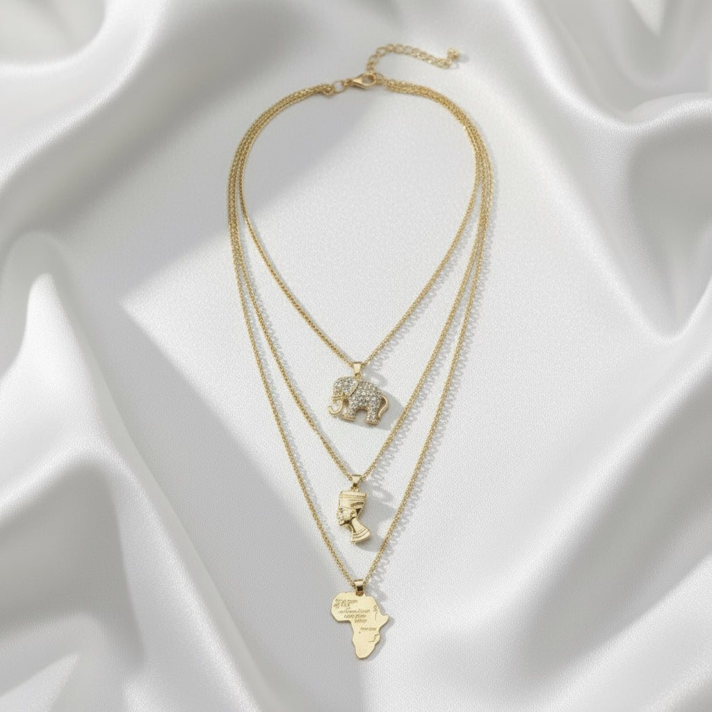 Gold necklaces with various pendants on a white fabric background