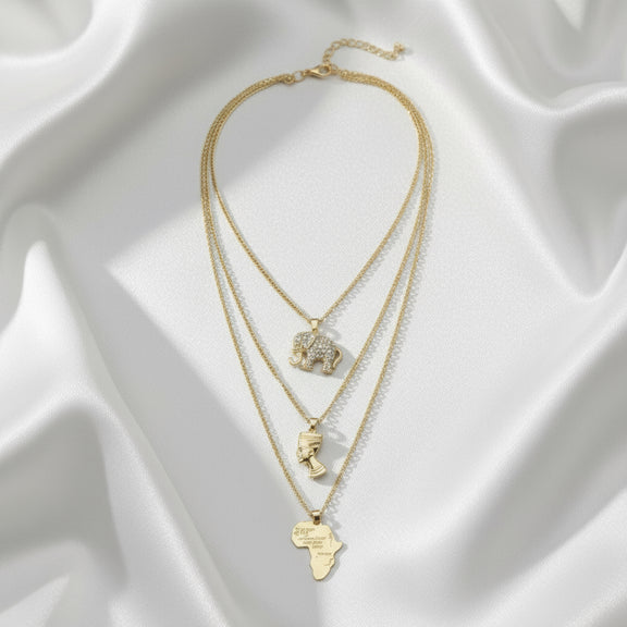 Gold necklaces with various pendants on a white fabric background