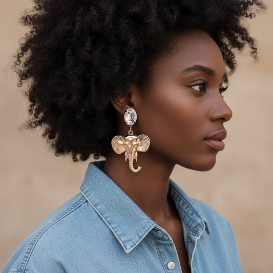 Gold elephant earrings with clear gemstones on a white background