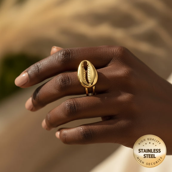 Gold open ring with shell design on a beige surface, featuring a 'High Quality Stainless Steel High Security' badge.