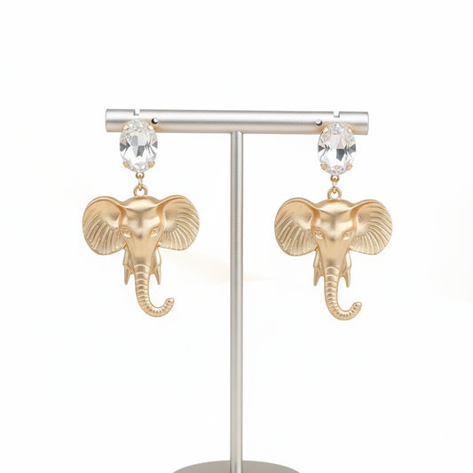 Gold elephant earrings on a light gray background