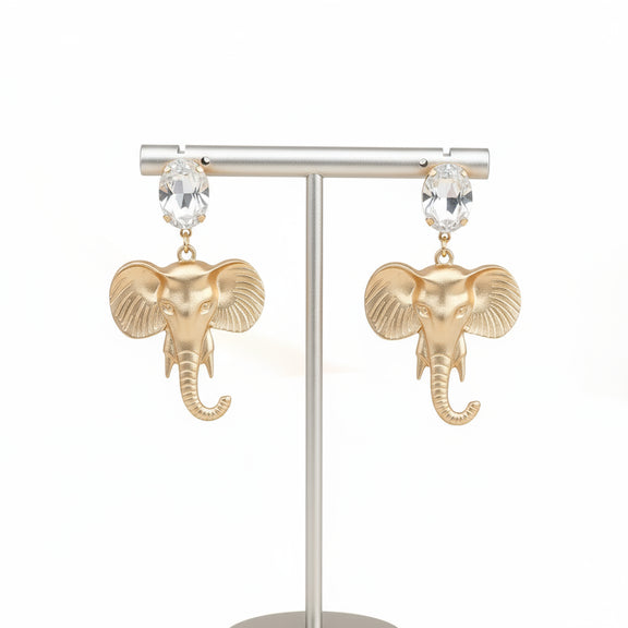 Gold elephant earrings on a light gray background