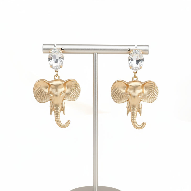 Gold elephant earrings on a light gray background